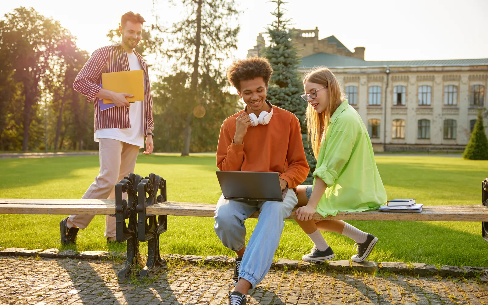University students working on a laptop on a campus lawn
