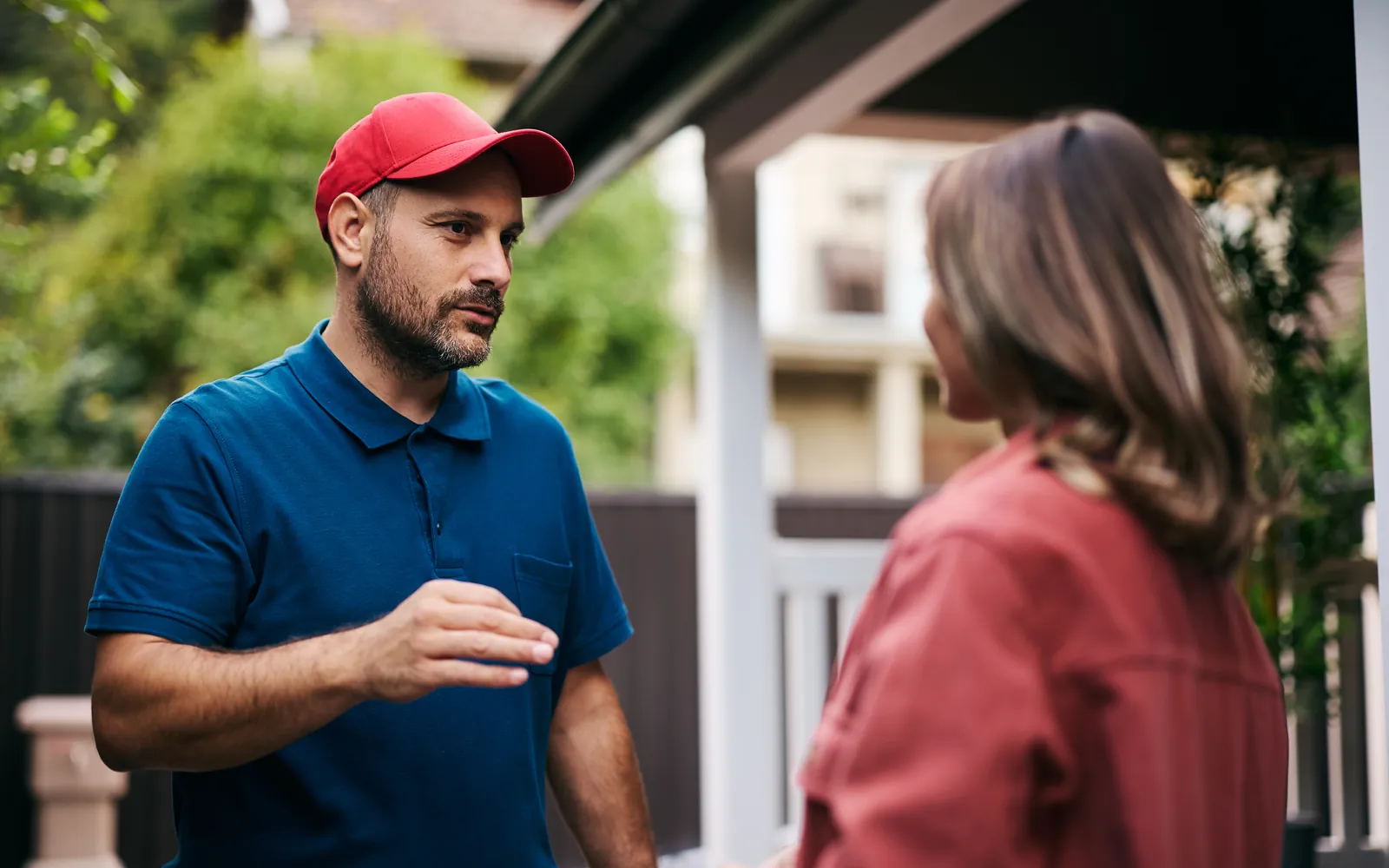 Home service professional talking with a homeowner on her front porch